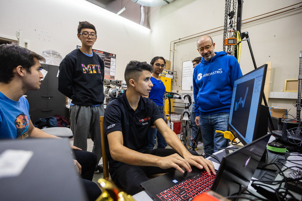 students and instructors in front of a desktop computer