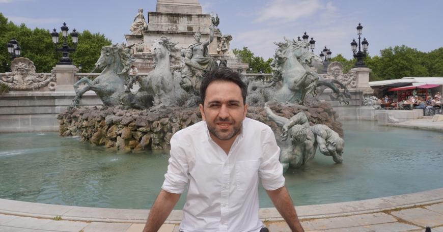 Gevorg Minasyan sits in front of a fountain.