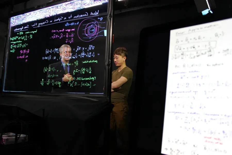 Two people stand behind a lightboard